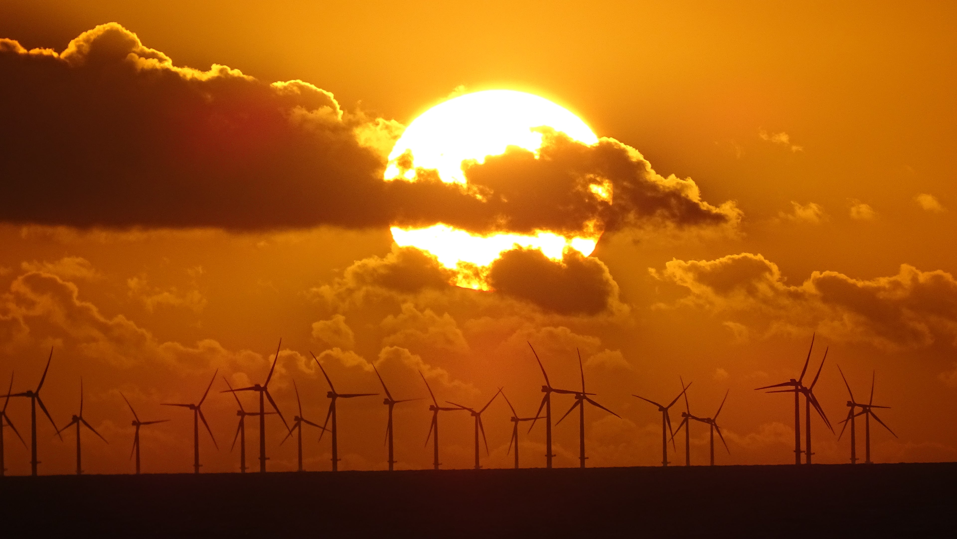 Dramatic golden sunset behind offshore wind turbines on the Sussex coast – original photography by Sharon Maskery