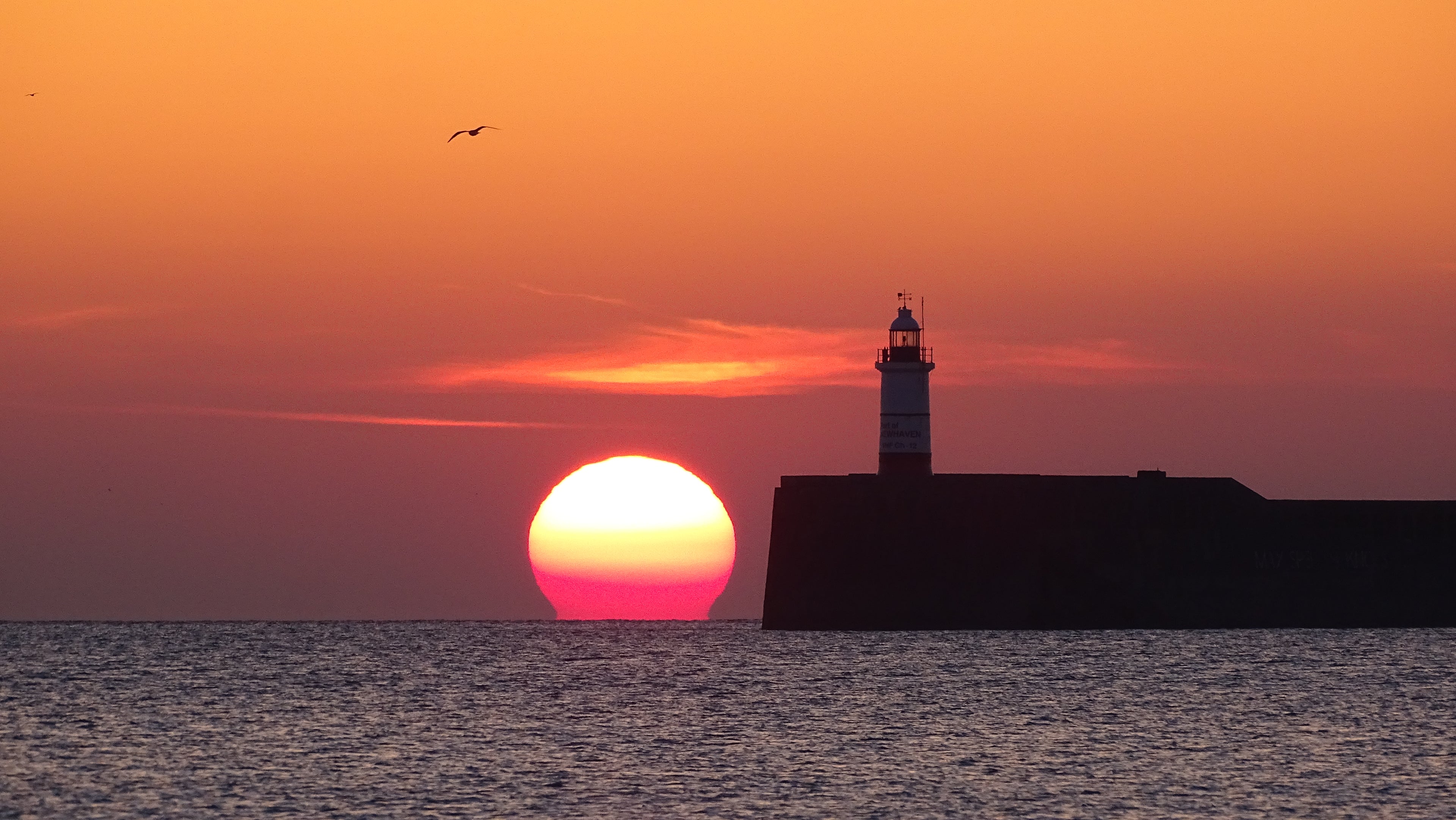 Beacon at Sunset, Newhaven Lighthouse at sunset on the Sussex coast